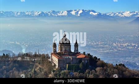 Vue aérienne de la basilique de Superga avec l'horizon de Turin entouré par les Alpes enneigées Banque D'Images