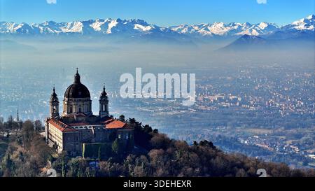 Vue aérienne de la basilique de Superga avec l'horizon de Turin entouré par les Alpes enneigées Banque D'Images