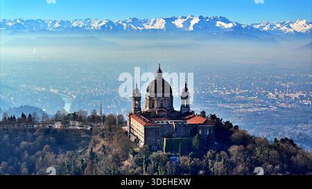 Vue aérienne de la basilique de Superga avec l'horizon de Turin entouré par les Alpes enneigées Banque D'Images