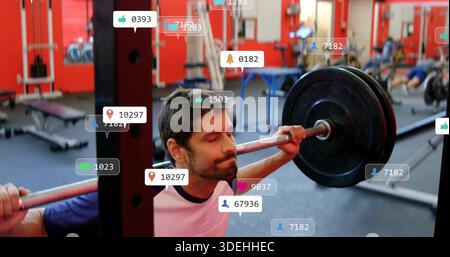 Homme barbu squatting dans un tee-shirt clair avec col foncé, saisissant barre chargée dans la salle de gym, avec des superpositions Banque D'Images