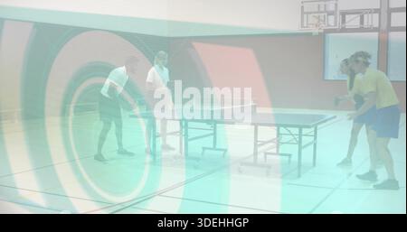 Jouer à quatre joueurs dans l'équipement athlétique, frapper des pagaies autour de table de tennis de table dans la salle de gym, avec balle Banque D'Images