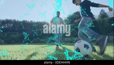 Jouer homme et garçon dans des vêtements de sport donnant des coups de pied monochrome ballon de football sur la pelouse ensoleillée, recouvrement turquoise Banque D'Images