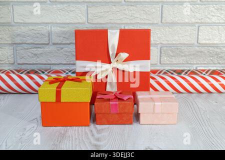 Les cadeaux emballés colorés sont disposés soigneusement sur une table avec un fond festif pendant la saison des fêtes dans un cadre intérieur Banque D'Images