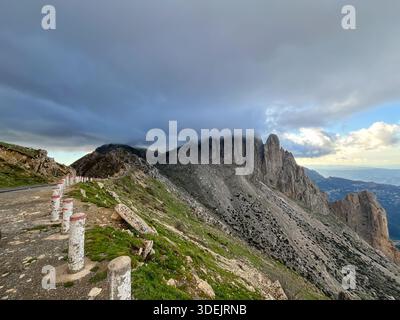Large vue panoramique sur les pics accidentés de la montagne Djurdjura et les vallées verdoyantes profondes sous un ciel nuageux spectaculaire en Algérie. Banque D'Images