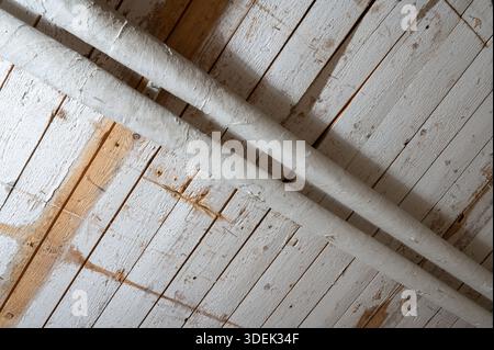 Gros plan d'un plafond en bois rustique avec des tuyaux exposés. Banque D'Images
