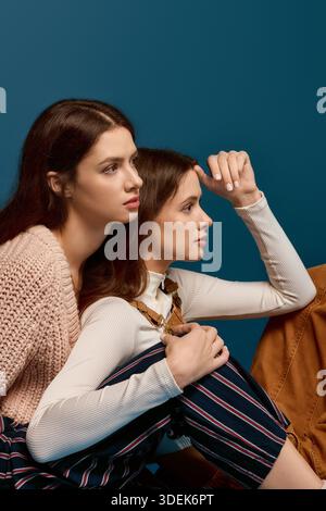 Deux jolies sœurs jumelles s'engagent dans une étreinte chaleureuse, mettant en valeur leur lien étroit et leur esprit ludique. Banque D'Images