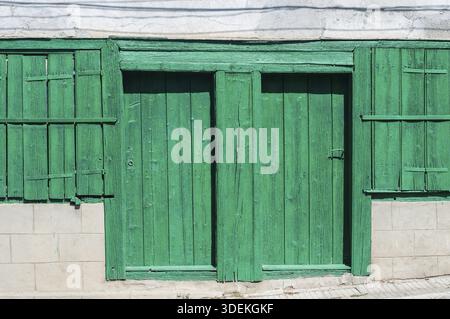 Ancienne maison rurale verte weathered porte en bois et volets de fenêtre closeup Banque D'Images