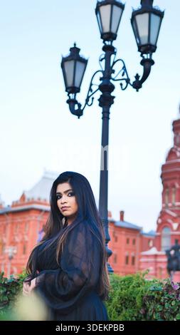 Jeune femme bengali regardant la caméra, debout près du lampadaire sur la place Rouge, Moscou Banque D'Images