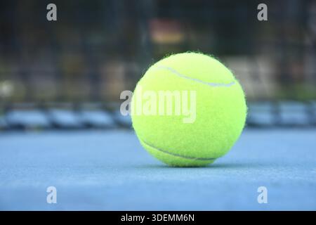 terrain jaune de chute de balle de tennis avec bordure blanche sur sol bleu Banque D'Images