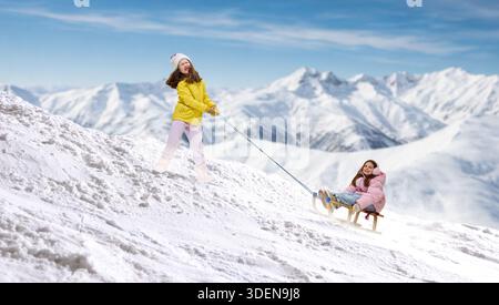 Œuvre d'art réconfortante de fille tirant le traîneau avec l'enfant souriant en montée. Banque D'Images