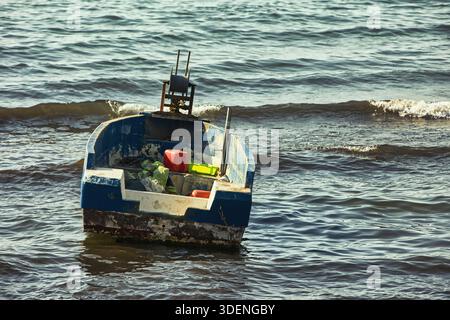 Le bateau flotte près de la rive à Vlorë, Albanie. Le bateau est rempli d'équipement, se balançant doucement sur la mer calme sous la lumière chaude de l'été 17.08.25 Banque D'Images