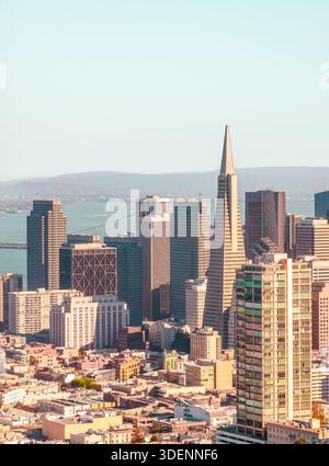 Vue aérienne de l'emblématique Transamerica Pyramid perçant la ligne d'horizon au milieu d'un groupe de gratte-ciel, avec la baie scintillante au loin, San Fran Banque D'Images