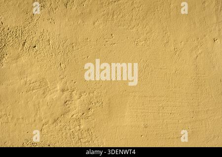 Closeup de mur de façade en plâtre rude maison ocre comme arrière-plan Banque D'Images