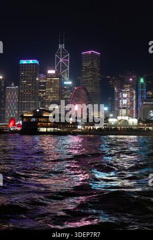 Vue nocturne sur le port de Victoria, l'emblématique skyline de Hong Kong comprend la tour Bank of China et la grande roue. Banque D'Images