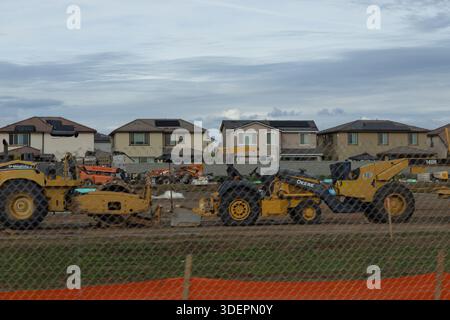 La machinerie lourde fonctionne sur un chantier de construction où des maisons sont construites dans un quartier de banlieue. Banque D'Images