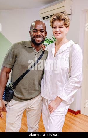 Heureux couple interracial célébrant l'annonce de grossesse à la maison Banque D'Images