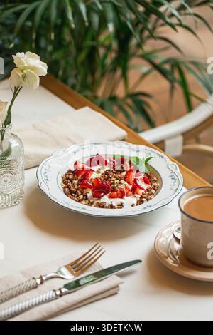 Bol de granola avec yaourt et fraises fraîches Banque D'Images