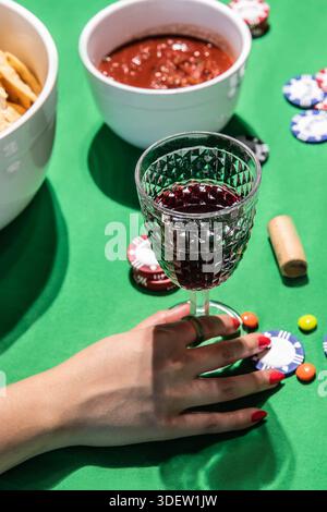 Personne appréciant le vin avec des collations pendant le jeu de poker à domicile Banque D'Images