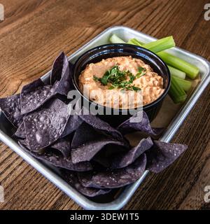 Trempette au fromage Pimento avec chips de tortilla de maïs bleu et céleri Banque D'Images