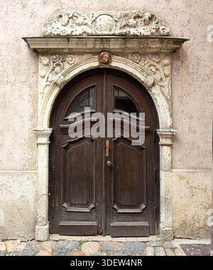 Entrée voûtée avec des sculptures en pierre complexes ouvrant sur un bâtiment historique Banque D'Images