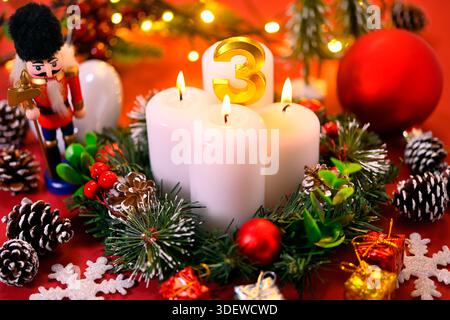 Couronne de l'Avent avec trois bougies allumées, photo symbolique du troisième Avent Banque D'Images