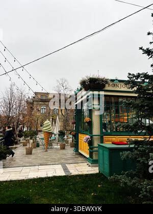 Chisinau, Moldavie - 29 novembre 2025 : charmante scène urbaine de café Bonjour avec un modèle décoratif de cône de crème glacée, des lumières chaudes et de la verdure à Chi Banque D'Images