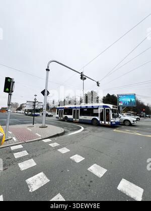 Chisinau, Moldavie - 29 novembre 2025 : scène de rue urbaine avec un tram et un bus à une intersection animée sous un ciel nuageux à Chisinau, Moldavie. Banque D'Images
