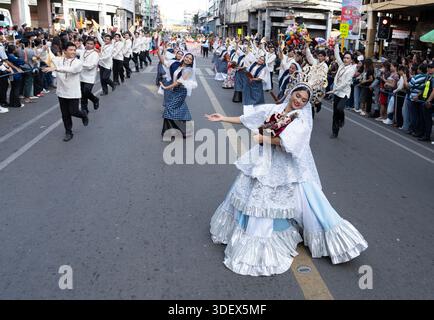 Les danseurs de rue exécutent une routine chorégraphiée lors d'un grand défilé culturel public tandis que la foule longe le parcours pour regarder. Banque D'Images