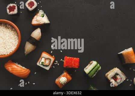 Fond de sushi et rouleaux, gros plan sur noir, vue de dessus. Banque D'Images
