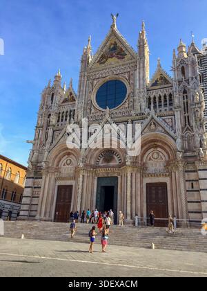 Piazza del Duomo à Sienne, Italie, la place historique entourant la cathédrale de Sienne, à l'architecture gothique frappante et faisant partie du centre médiéval de la ville classé au patrimoine mondial de l'UNESCO le Duomo di Siena, ou cathédrale de Sienne, à Sienne, en Italie, un chef-d'œuvre de l'architecture gothique italienne se distinguant par sa façade en marbre rayé et son riche patrimoine artistique au cœur de la Toscane Banque D'Images