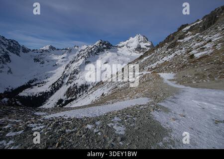 Vue sur les montagnes enneigées percer le ciel bleu vif, tandis que le terrain accidenté rencontre le paysage blanc de Vysoke Tatry, région de Presov, Slovaquie. Banque D'Images