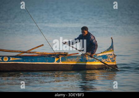 Partez pêcher dans un canoë-kayak, connu localement sous le nom de piroque, dans la lumière du petit matin. La pêche à Morombe, une ville côtière du sud-ouest de Madagascar, est une partie essentielle de l'économie et de la culture locales, principalement motivée par les méthodes artisanales et traditionnelles utilisées par le peuple Vezo, qui sont des pêcheurs traditionnels et se considèrent comme les propriétaires de la mer. Morombe, Madagascar. Banque D'Images