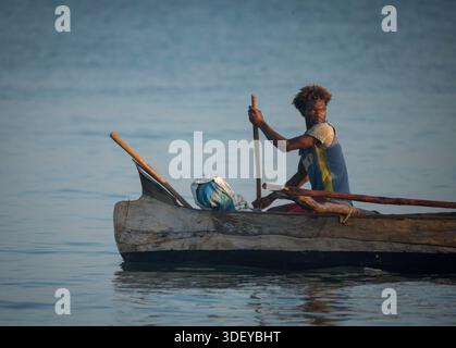 Pêcheur malgache partant pêcher dans un canot à balancier, localement connu sous le nom de piroque, dans la lumière tôt le matin. La pêche à Morombe, une ville côtière du sud-ouest de Madagascar, est une partie essentielle de l'économie et de la culture locales, principalement motivée par les méthodes artisanales et traditionnelles utilisées par le peuple Vezo, qui sont des pêcheurs traditionnels et se considèrent comme les propriétaires de la mer. Morombe, Madagascar. Banque D'Images