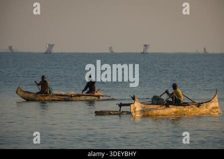 Pêcheurs malgaches partant pêcher dans un canoë-balancier, localement connu sous le nom de piroque, dans la lumière du petit matin. La pêche à Morombe, une ville côtière du sud-ouest de Madagascar, est une partie essentielle de l'économie et de la culture locales, principalement motivée par les méthodes artisanales et traditionnelles utilisées par le peuple Vezo, qui sont des pêcheurs traditionnels et se considèrent comme les propriétaires de la mer. Morombe, Madagascar. Banque D'Images