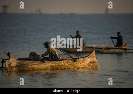 Pêcheurs malgaches partant pêcher dans un canoë-balancier, localement connu sous le nom de piroque, dans la lumière du petit matin. La pêche à Morombe, une ville côtière du sud-ouest de Madagascar, est une partie essentielle de l'économie et de la culture locales, principalement motivée par les méthodes artisanales et traditionnelles utilisées par le peuple Vezo, qui sont des pêcheurs traditionnels et se considèrent comme les propriétaires de la mer. Morombe, Madagascar. Banque D'Images