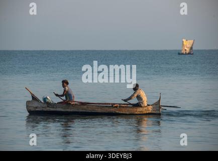 Pêcheurs malgaches partant pêcher dans un canoë-balancier, localement connu sous le nom de piroque, dans la lumière du petit matin. La pêche à Morombe, une ville côtière du sud-ouest de Madagascar, est une partie essentielle de l'économie et de la culture locales, principalement motivée par les méthodes artisanales et traditionnelles utilisées par le peuple Vezo, qui sont des pêcheurs traditionnels et se considèrent comme les propriétaires de la mer. Morombe, Madagascar. Banque D'Images