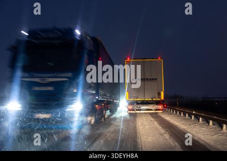Magdebourg, Allemagne. 9 janvier 2026. Camion conduisant dans la tempête de neige Elli en Allemagne la nuit. Les routes verglacées et les fortes chutes de neige créent des conditions de transport dangereuses en hiver. Banque D'Images