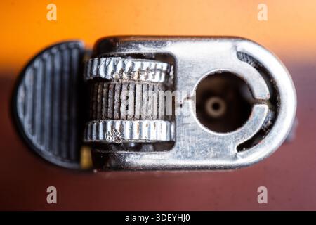 Vue de dessus extrêmement rapprochée de la roue en silex d'un briquet classique. Présente une texture métallique, des détails mécaniques et une faible profondeur de champ. Banque D'Images
