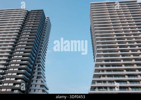 Gratte-ciel moderne de grande hauteur avec balcons répétés contre le ciel bleu Banque D'Images