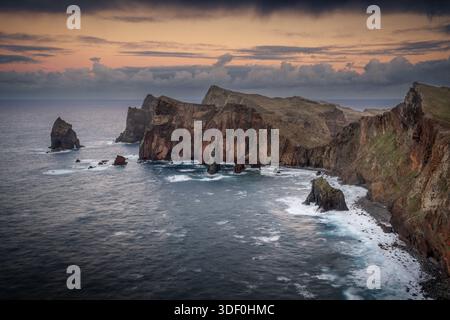 Coucher de soleil sur Ponta de Sao Lourenco avec ciel orange spectaculaire et nuages sur la côte accidentée de l'île de Madère. Banque D'Images