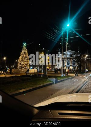 Lviv, Ukraine - 29 novembre 2025 : une vue nocturne animée d'un arbre de Noël sur une place de la ville, une rue illuminée et des piétons à Lviv, en Ukraine. Banque D'Images