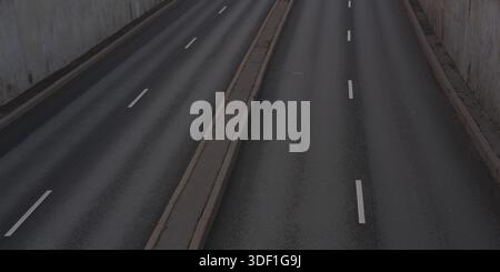 Route vide avec marquage des voies et murs en béton des deux côtés. Rues de la ville, autoroute vide le soir ou la nuit Banque D'Images
