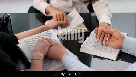 Groupe diversifié d'amis priant ensemble avec leur Bible. Banque D'Images