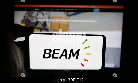 Dans cette illustration photo, une personne tient un téléphone portable avec le logo de la société américaine de recharge EV Beam Global sur l'écran en face de la page Web. Banque D'Images