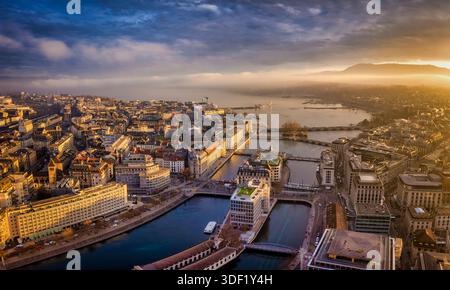 Vue aérienne du paysage urbain de Genève, Suisse, lors d'un beau lever de soleil d'hiver avec lumière douce et brouillard Banque D'Images