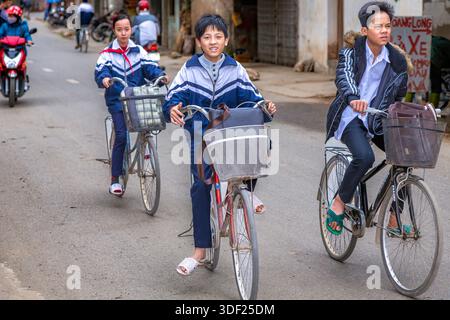 Écoliers vietnamiens faisant du vélo, commune de SAI son, district de Quoc Oai, banlieue de Hanoi, Vietnam Banque D'Images