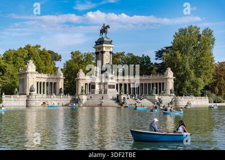 MADRID, ESPAGNE - 16 OCTOBRE 2025 : touristes ramant des bateaux bleus sur le lac devant le Monument à Alphonse XII au parc El Retiro par une journée ensoleillée Banque D'Images
