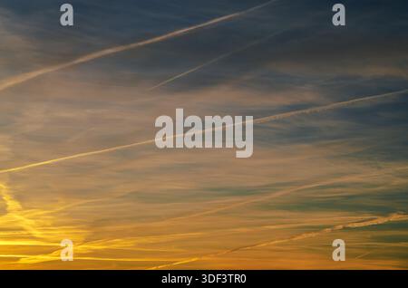 Ciel de coucher de soleil avec des traînées créant des motifs abstraits à travers l'horizon Banque D'Images