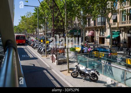 Scène de rue urbaine avec motos, taxis et piétons à Barcelone Banque D'Images