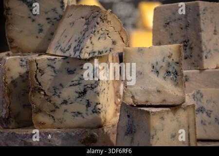 Gros plan de quartiers de fromage bleu Stilton sur un étal de fromagers sur un marché alimentaire Banque D'Images